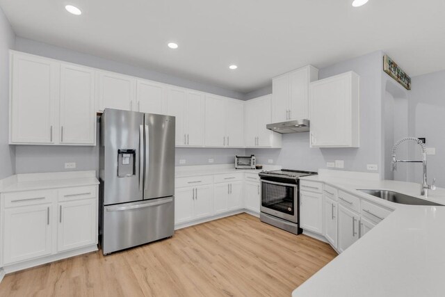 kitchen with recessed lighting, a sink, under cabinet range hood, and stainless steel appliances