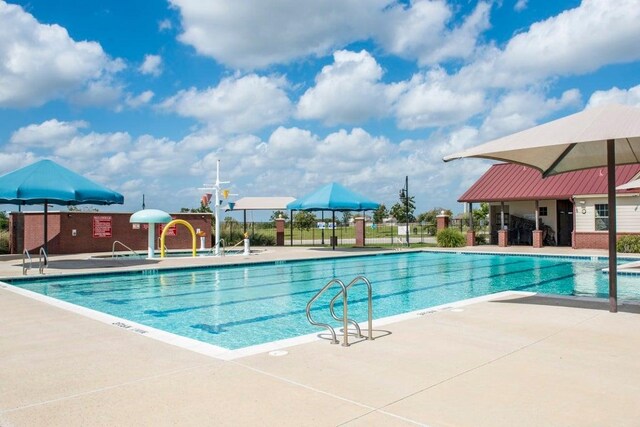 pool featuring fence and a patio