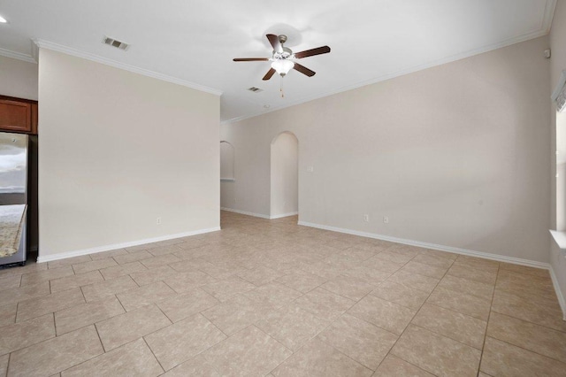 empty room with ceiling fan, visible vents, arched walkways, baseboards, and ornamental molding