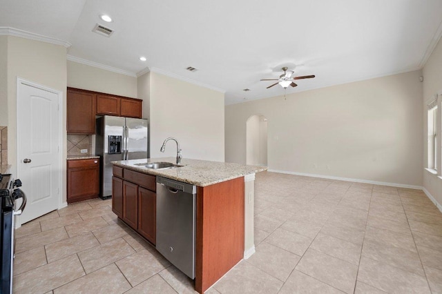kitchen featuring ceiling fan, light stone countertops, a sink, arched walkways, and stainless steel appliances