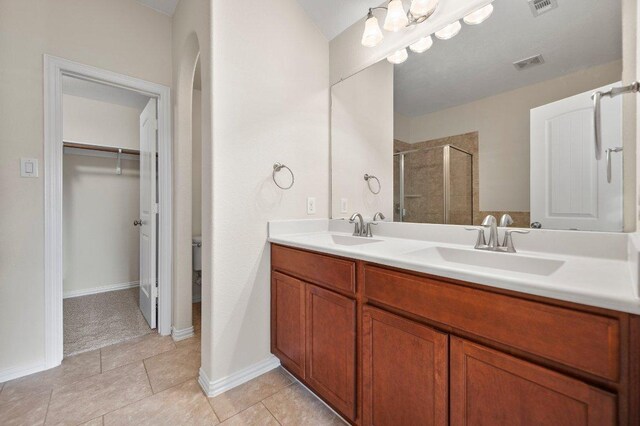 full bath featuring a sink, a walk in closet, a stall shower, and visible vents