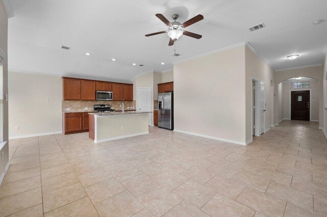 1364 Star Mdw, Kyle, TX 78640 - kitchen with stainless steel appliances, open floor plan, arched walkways, decorative backsplash, and ceiling fan