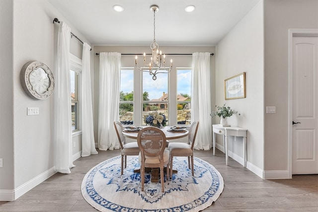 dining space with recessed lighting, baseboards, a chandelier, and wood finished floors