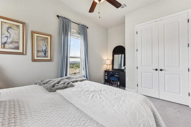 carpeted bedroom with ceiling fan, a closet, and visible vents