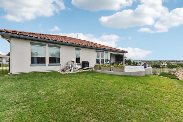 rear view of house featuring a lawn, fence, a tile roof, and a patio