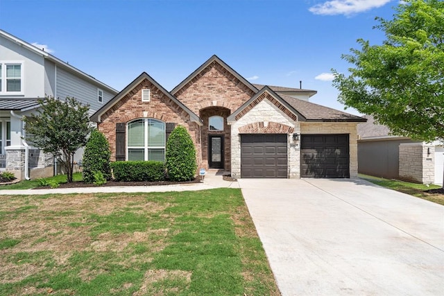 french country inspired facade featuring a front lawn, stone siding, a garage, brick siding, and driveway