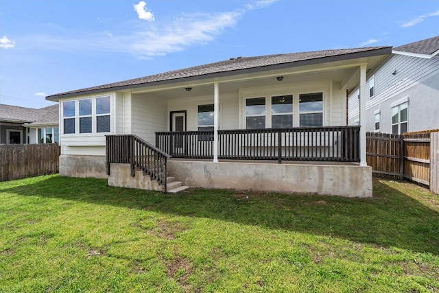 rear view of house featuring a yard, fence private yard, and a porch