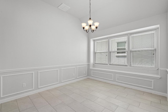 unfurnished room featuring a chandelier, visible vents, a wainscoted wall, lofted ceiling, and a decorative wall