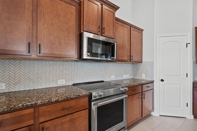 8105 Porto Cv, Round Rock, TX 78665 - kitchen featuring stainless steel appliances, dark stone countertops, tasteful backsplash, and light tile patterned floors