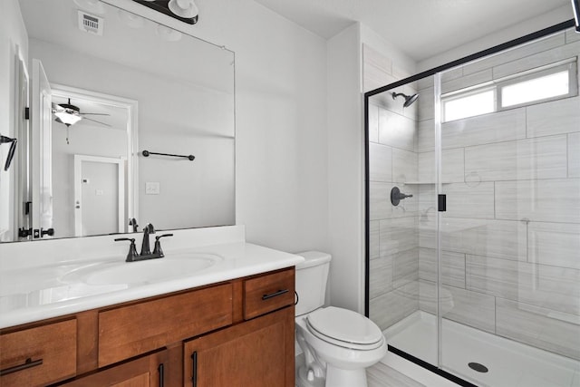 bathroom featuring a ceiling fan, visible vents, a stall shower, vanity, and toilet