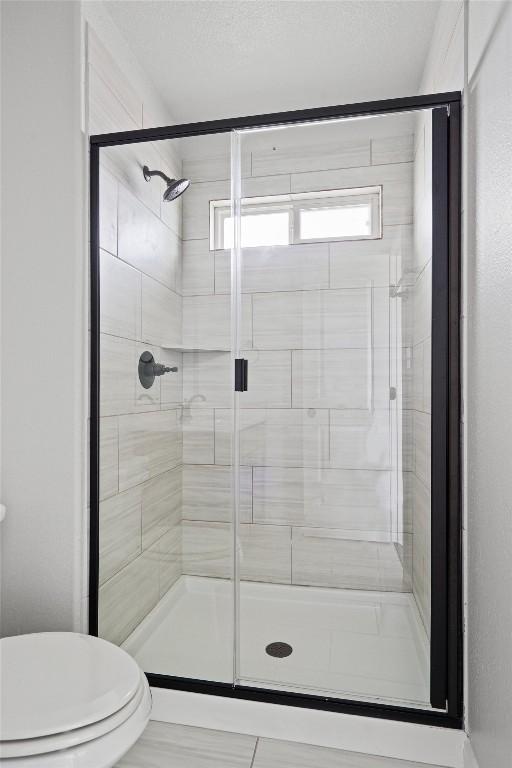 bathroom with toilet and a shower stall
