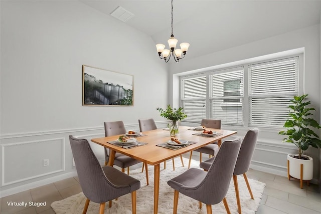 8105 Porto Cv, Round Rock, TX 78665 - dining space with a decorative wall, a chandelier, lofted ceiling, light tile patterned flooring, and wainscoting