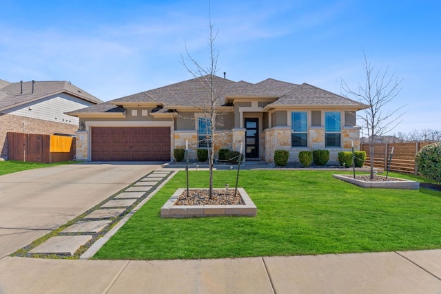 prairie-style home featuring an attached garage, driveway, stucco siding, and stone siding