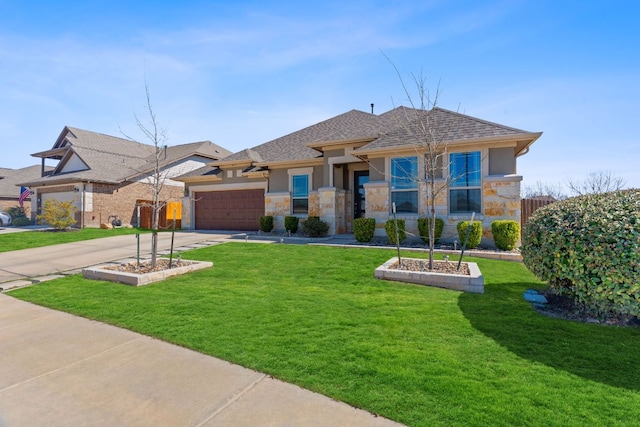prairie-style home featuring driveway, a front yard, an attached garage, stone siding, and stucco siding