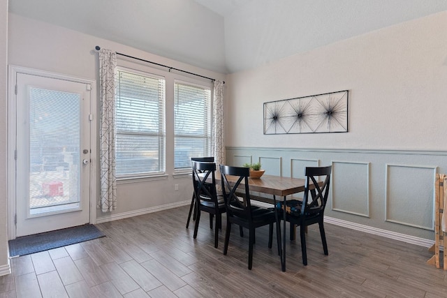 dining space with wood finished floors, baseboards, and lofted ceiling