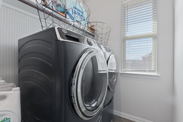 laundry room with baseboards, laundry area, dark wood-type flooring, and washer and clothes dryer
