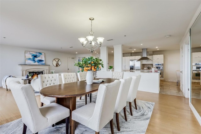 40 N Interstate 35 Unit 10B1, Austin, TX 78701 - dining area with a chandelier, light wood-type flooring, recessed lighting, and a glass covered fireplace