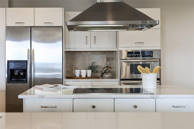 40 N Interstate 35 Unit 10B1, Austin, TX 78701 - kitchen featuring ventilation hood, stainless steel fridge, white cabinetry, black electric cooktop, and backsplash