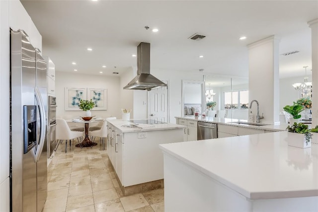 40 N Interstate 35 Unit 10B1, Austin, TX 78701 - kitchen featuring appliances with stainless steel finishes, island range hood, a large island, a chandelier, and white cabinetry