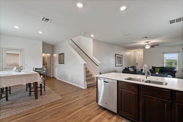 kitchen featuring stainless steel dishwasher, a sink, visible vents, and open floor plan