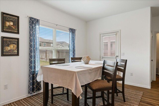 dining space featuring baseboards, dark wood finished floors, and plenty of natural light