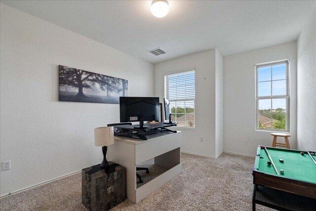 home office featuring baseboards, visible vents, and light carpet