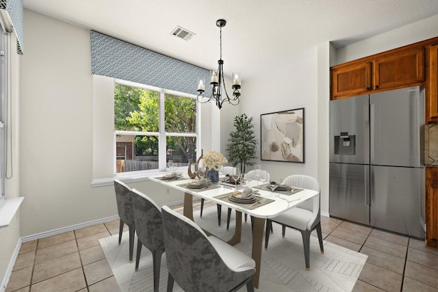 dining room featuring baseboards, an inviting chandelier, light tile patterned floors, and visible vents