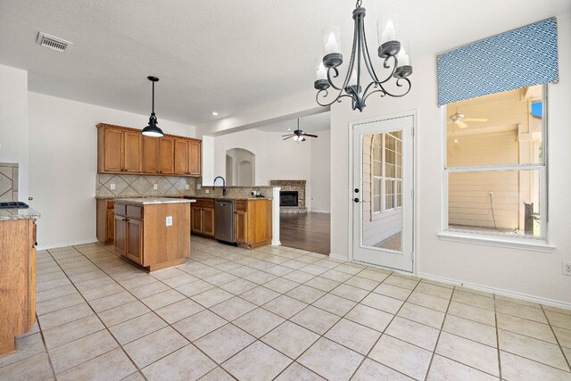 20312 Bellerive Dr, Pflugerville, TX 78660 - kitchen featuring ceiling fan, brown cabinetry, tasteful backsplash, and open floor plan
