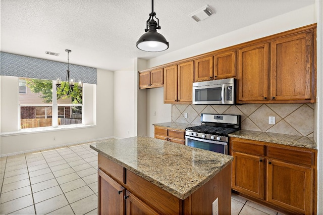 kitchen with a kitchen island, brown cabinetry, stainless steel appliances, and visible vents
