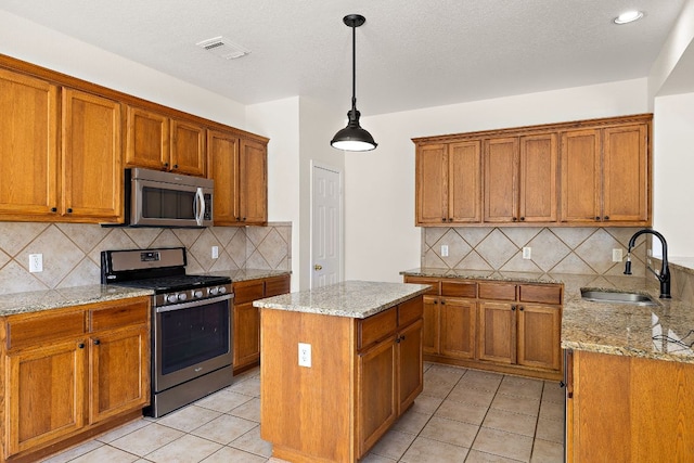 kitchen featuring appliances with stainless steel finishes, brown cabinetry, a sink, and tasteful backsplash