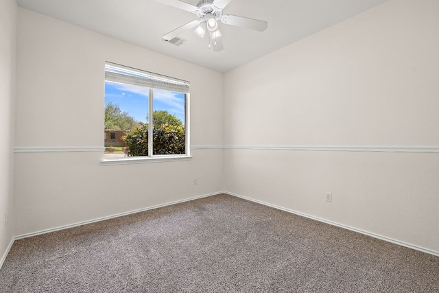 spare room with carpet flooring, ceiling fan, visible vents, and baseboards