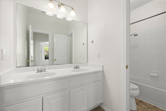 bathroom with a sink, a textured wall, and toilet