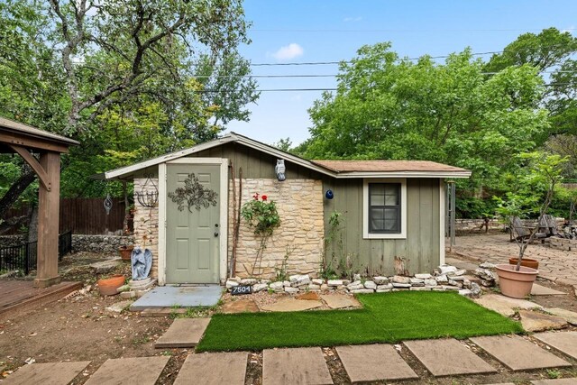 7504 Creekbluff Dr, Austin, TX 78750 - view of front of home featuring stone siding and an outdoor structure