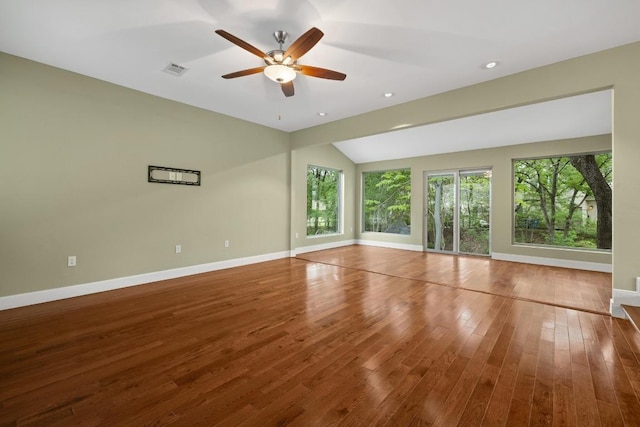 empty room with ceiling fan, baseboards, vaulted ceiling, visible vents, and hardwood / wood-style flooring