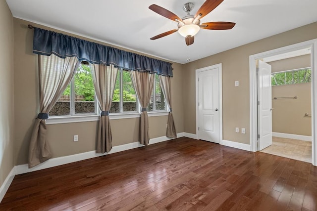 unfurnished bedroom featuring baseboards, multiple windows, and hardwood / wood-style floors