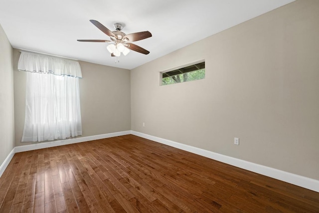 empty room with wood-type flooring, a ceiling fan, and baseboards