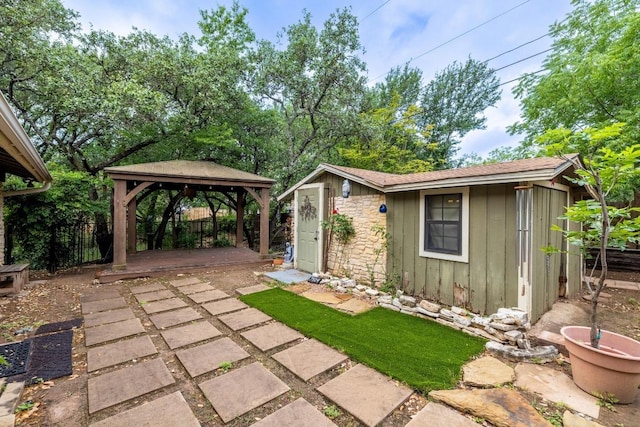 exterior space featuring fence, an outdoor structure, and a gazebo