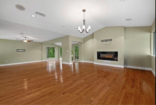 unfurnished living room with a glass covered fireplace, baseboards, vaulted ceiling, and wood finished floors