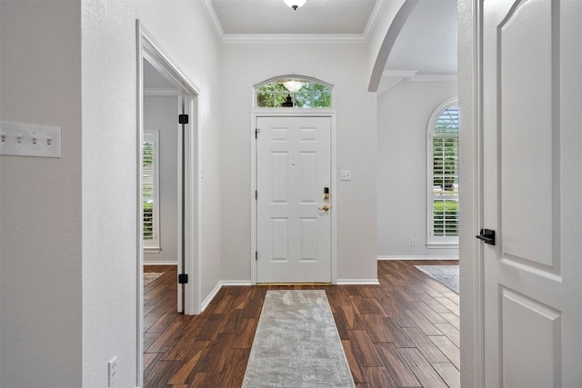 entryway featuring arched walkways, baseboards, dark wood finished floors, and ornamental molding