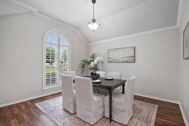 dining area with baseboards, crown molding, wood finished floors, and vaulted ceiling