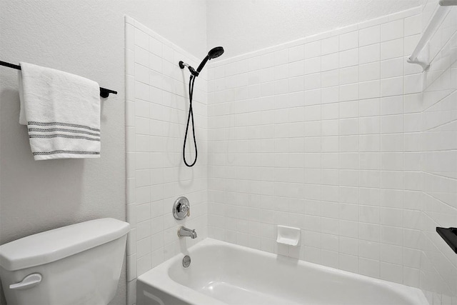 full bathroom featuring toilet, a textured wall, and bathing tub / shower combination