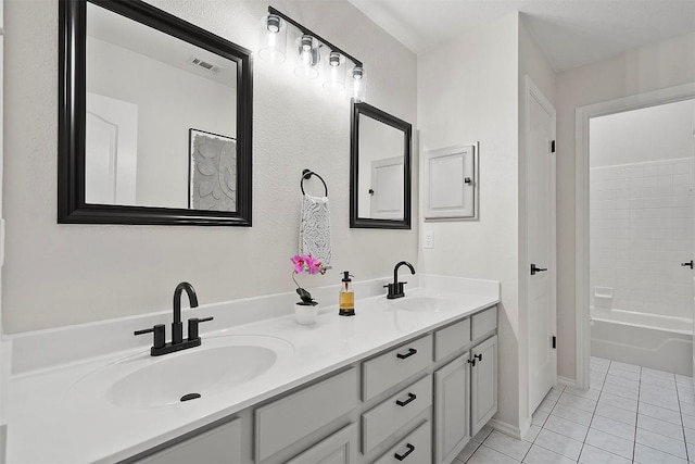 full bathroom with double vanity, visible vents, a sink, and tile patterned flooring