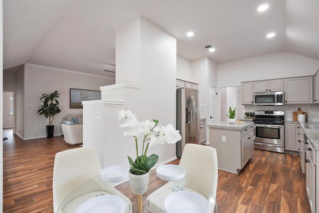 kitchen with vaulted ceiling, a center island, stainless steel appliances, and dark wood-style floors