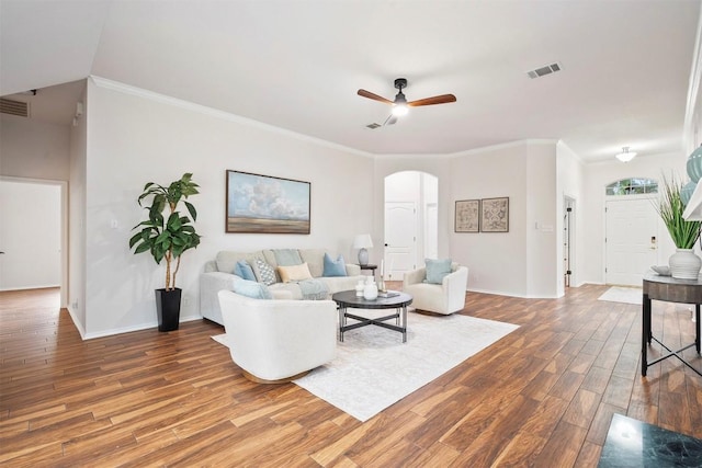 living room featuring ceiling fan, visible vents, arched walkways, wood finished floors, and baseboards