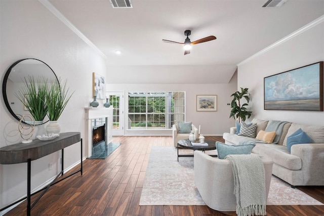 living area featuring a ceiling fan, visible vents, a fireplace, dark wood-style floors, and ornamental molding