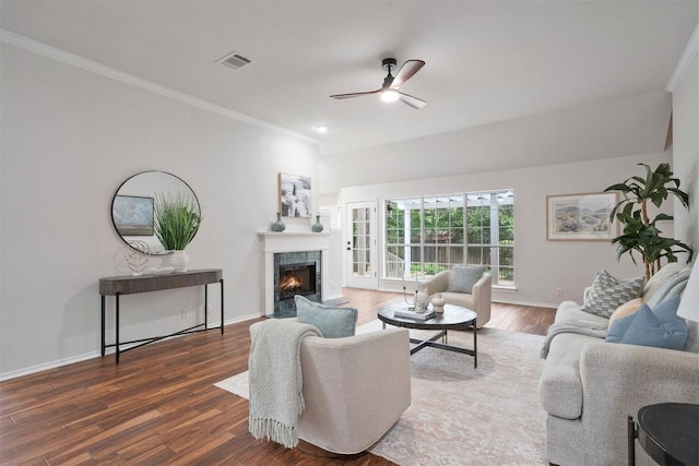 living area featuring crown molding, ceiling fan, a premium fireplace, wood finished floors, and visible vents