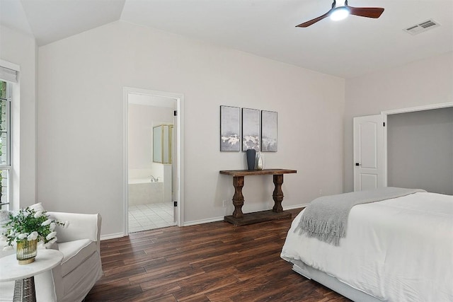 bedroom with visible vents, lofted ceiling, baseboards, ensuite bathroom, and dark wood-type flooring
