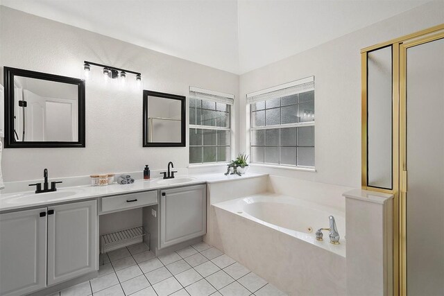 bathroom featuring tile patterned flooring, a sink, double vanity, and a tub with jets