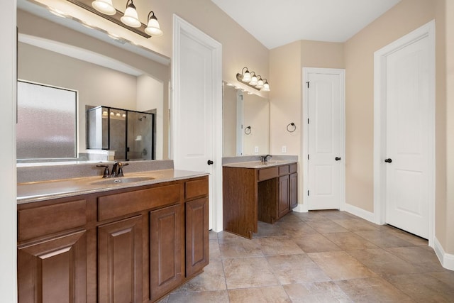 full bath with a sink, baseboards, a stall shower, and two vanities