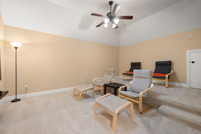 sitting room featuring a ceiling fan, baseboards, light colored carpet, and vaulted ceiling